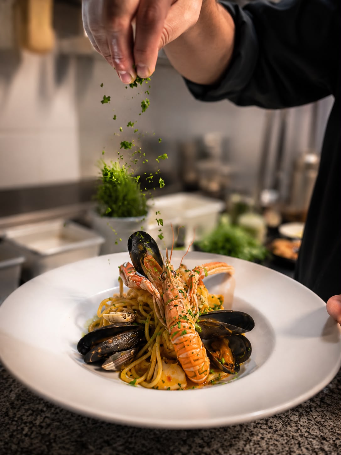 Chef terminando una pasta con marisco
